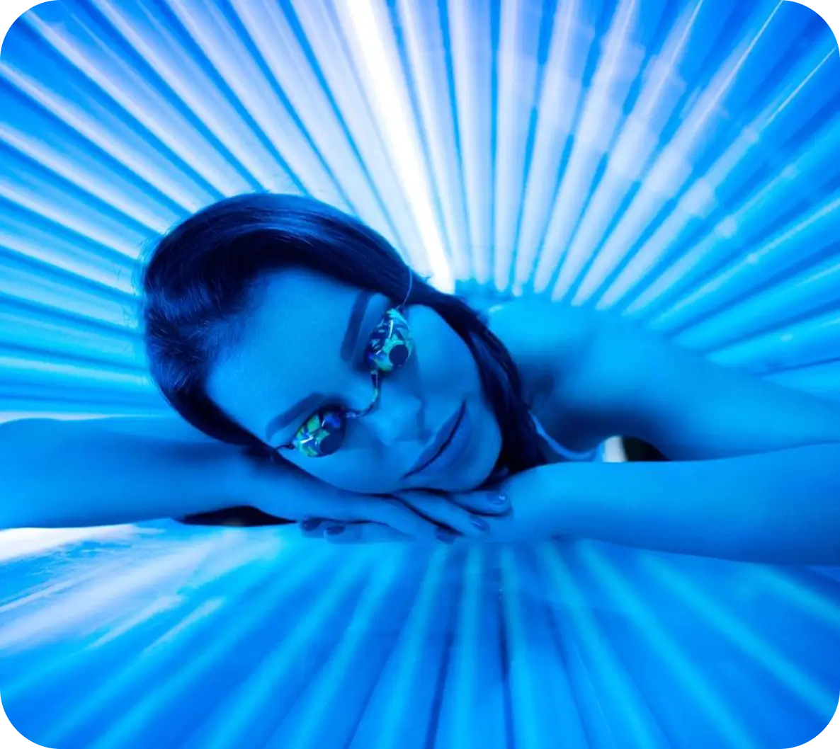 A woman laying in an enclosed tanning bed.